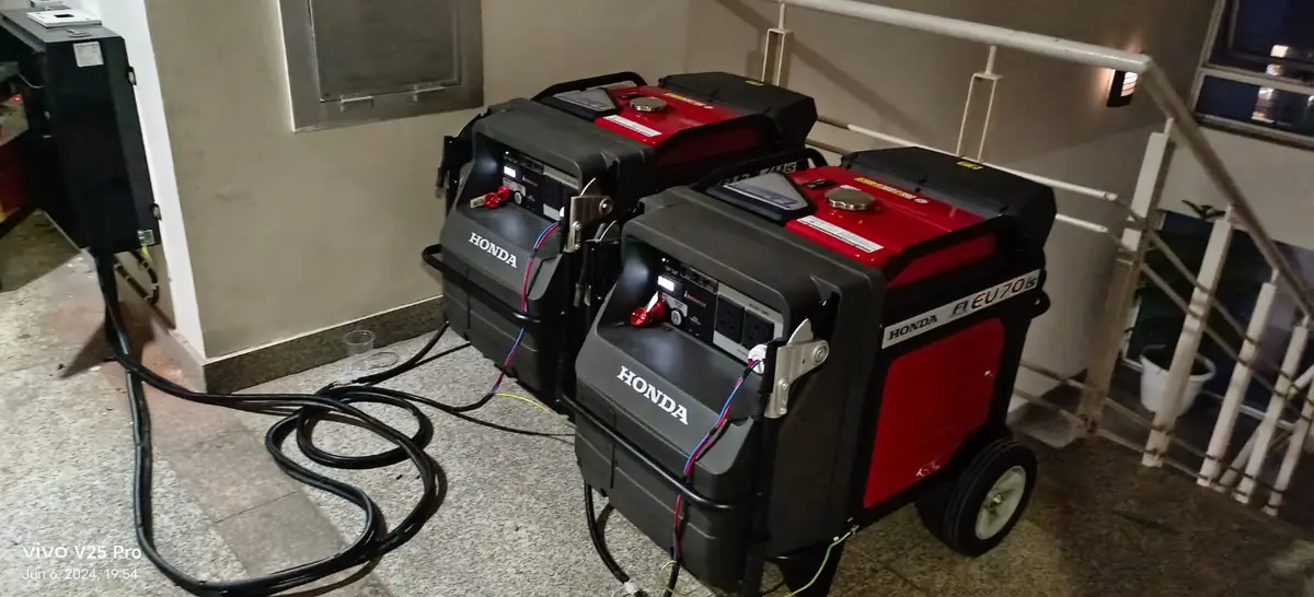 Two Honda EU70is inverter generators installed under a staircase in a Delhi home